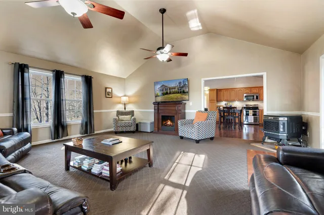 a living room with furniture a large window and a chandelier