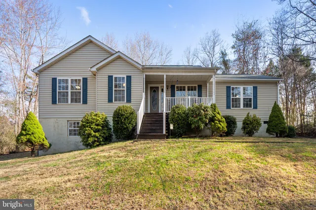 a view of a house with potted plants and large trees