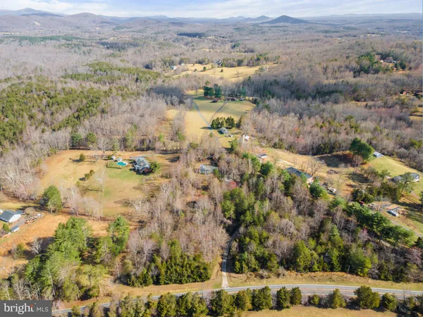an aerial view of a house with a mountain