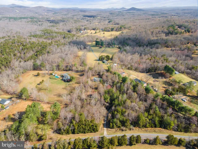 an aerial view of a house with a mountain