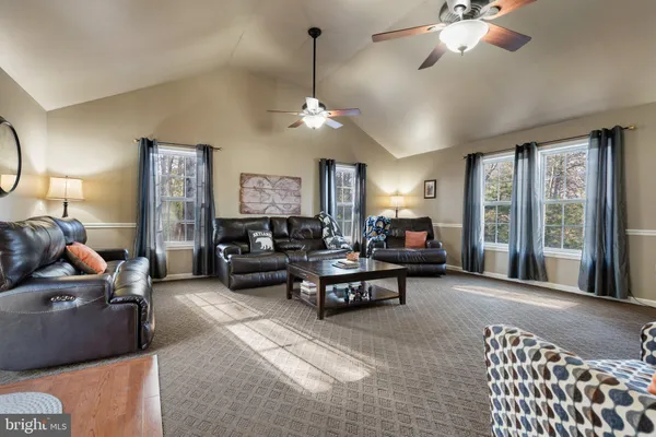 a living room with furniture a fireplace and a chandelier