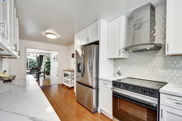 a kitchen with stainless steel appliances a stove a refrigerator and a refrigerator