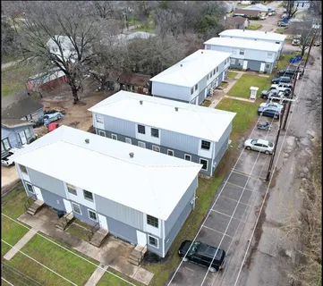 an aerial view of a house with a yard and furniture
