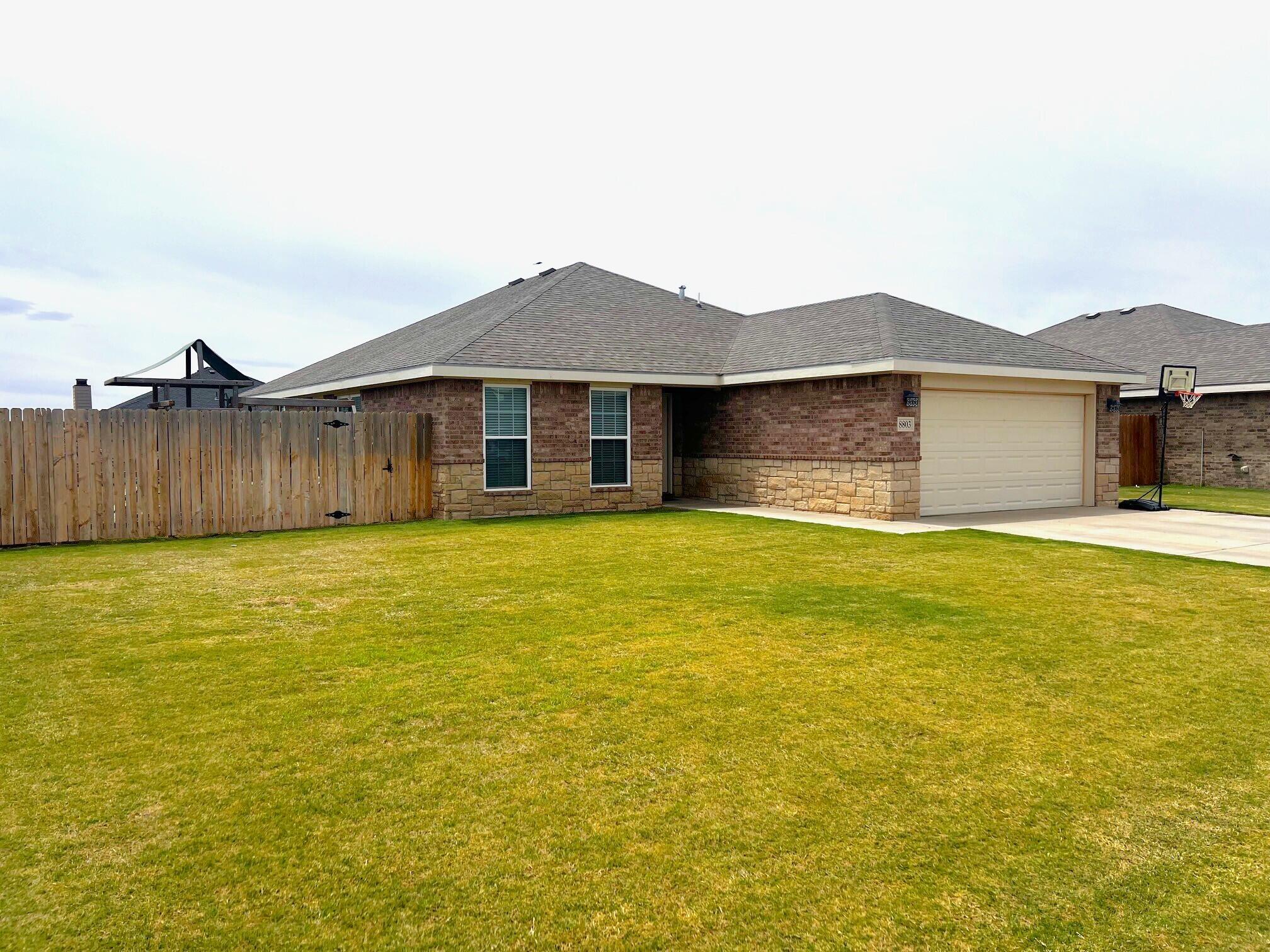 8803 10th Place Lubbock, TX 79416 - Photo 1 of 27 a front view of a house with a yard