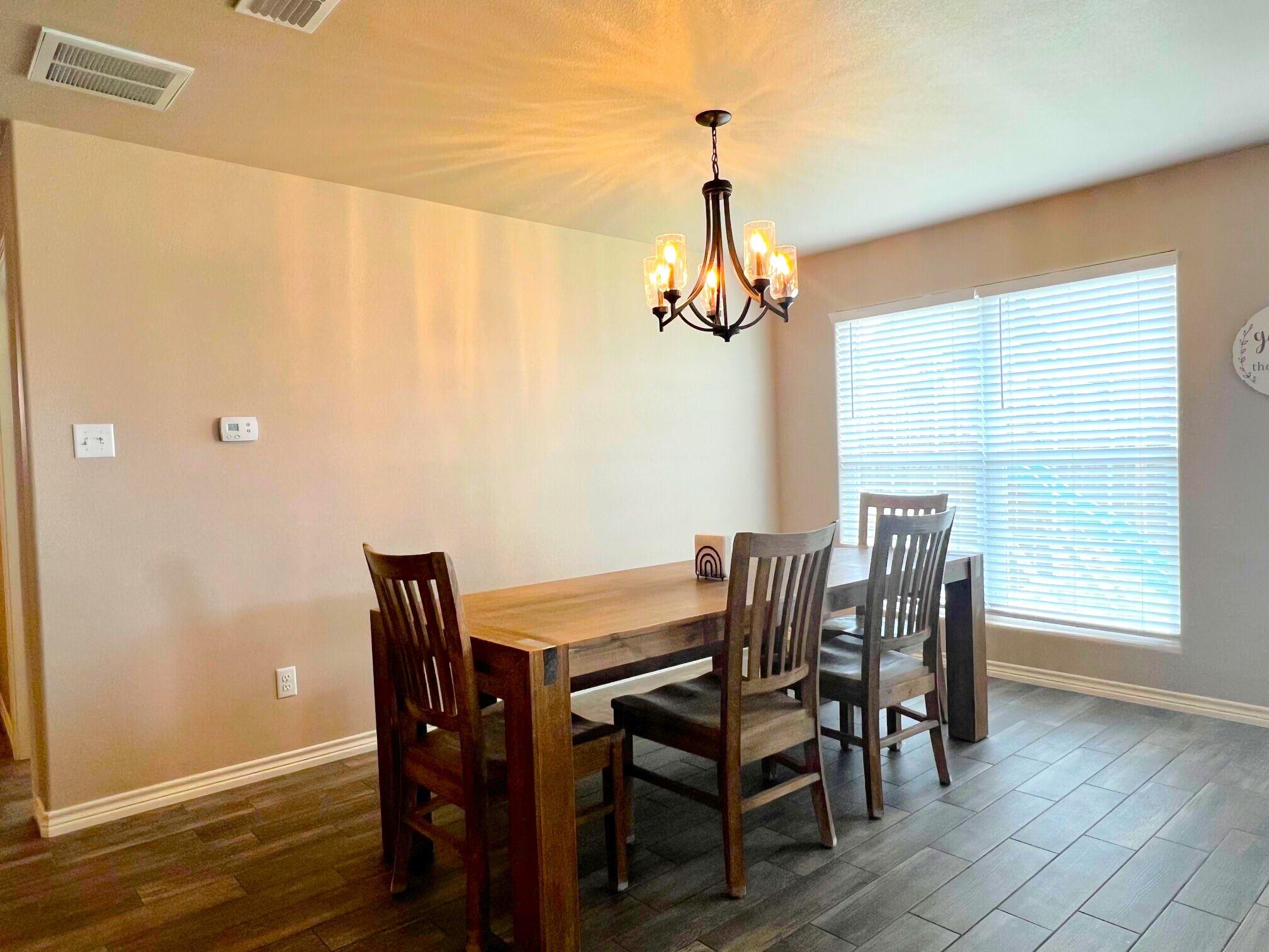 8803 10th Place Lubbock, TX 79416 - Photo 12 of 27 a view of a dining room with furniture and wooden floor