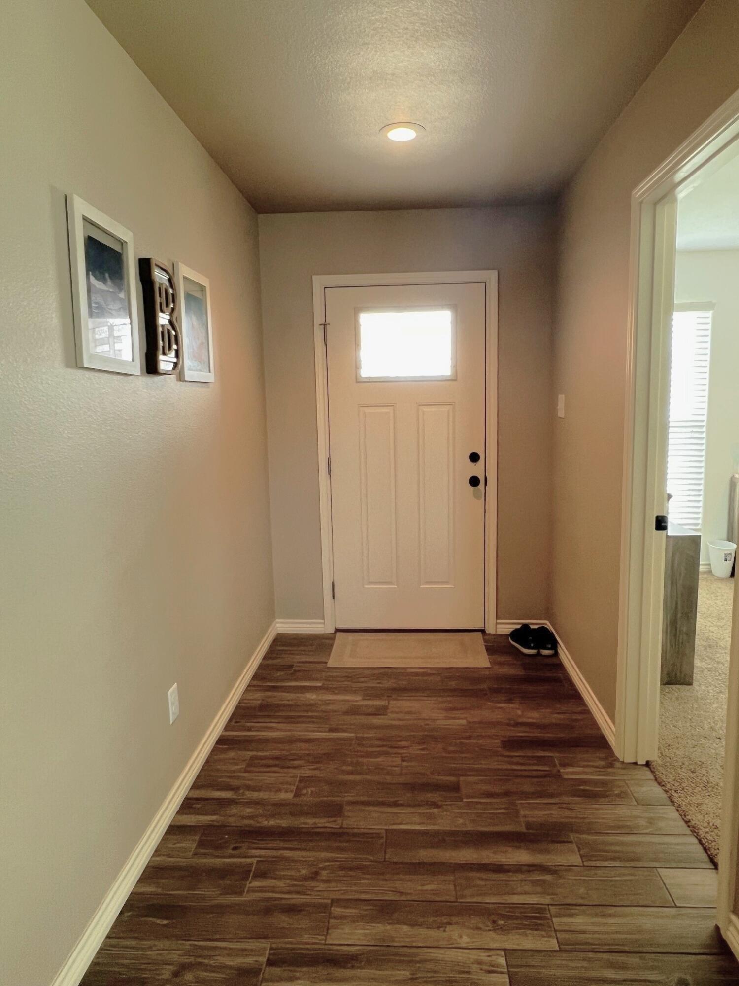 8803 10th Place Lubbock, TX 79416 - Photo 13 of 27 a view of an empty room with wooden floor and a window
