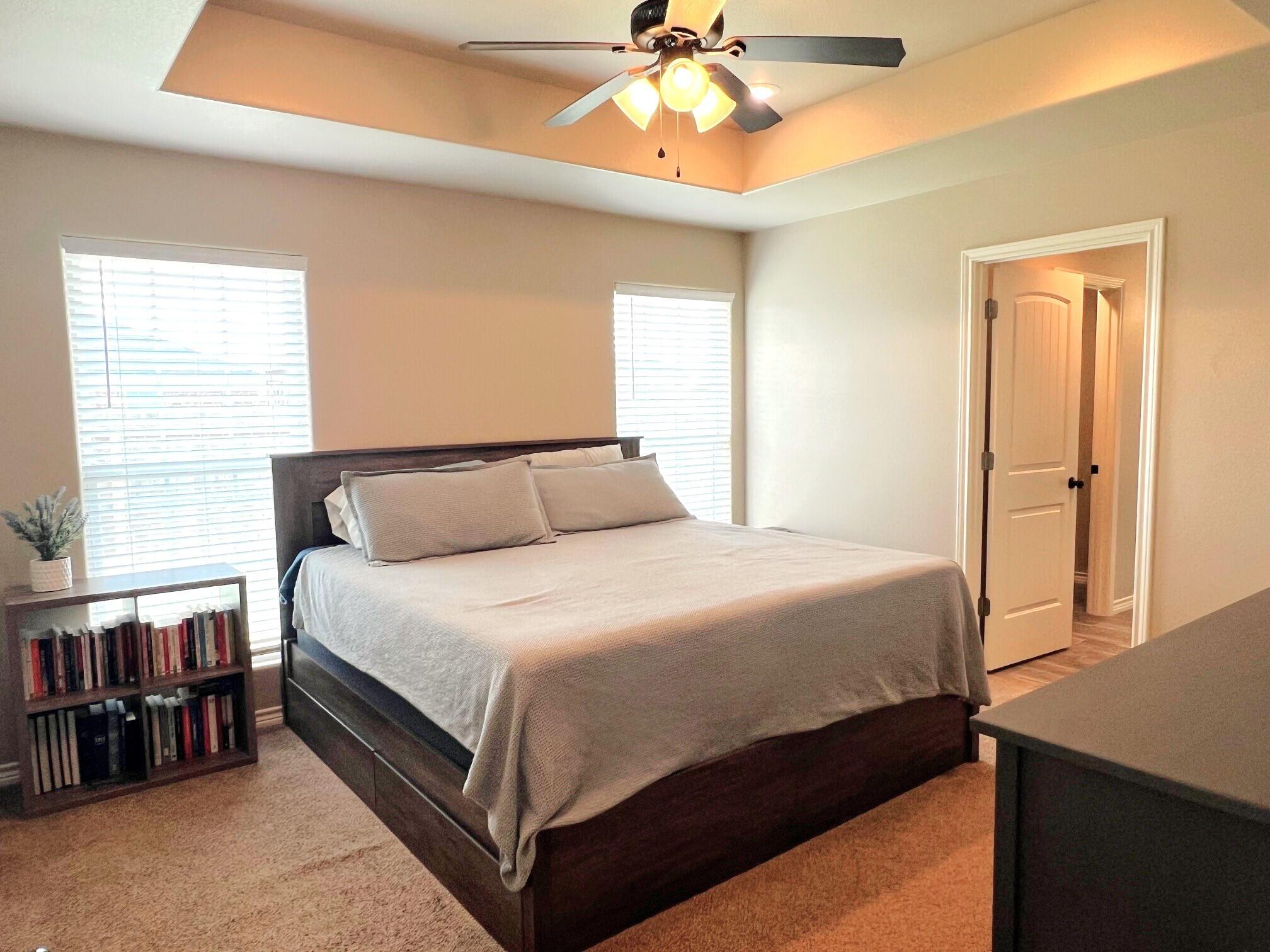 8803 10th Place Lubbock, TX 79416 - Photo 14 of 27 a bedroom with a bed and a chandelier