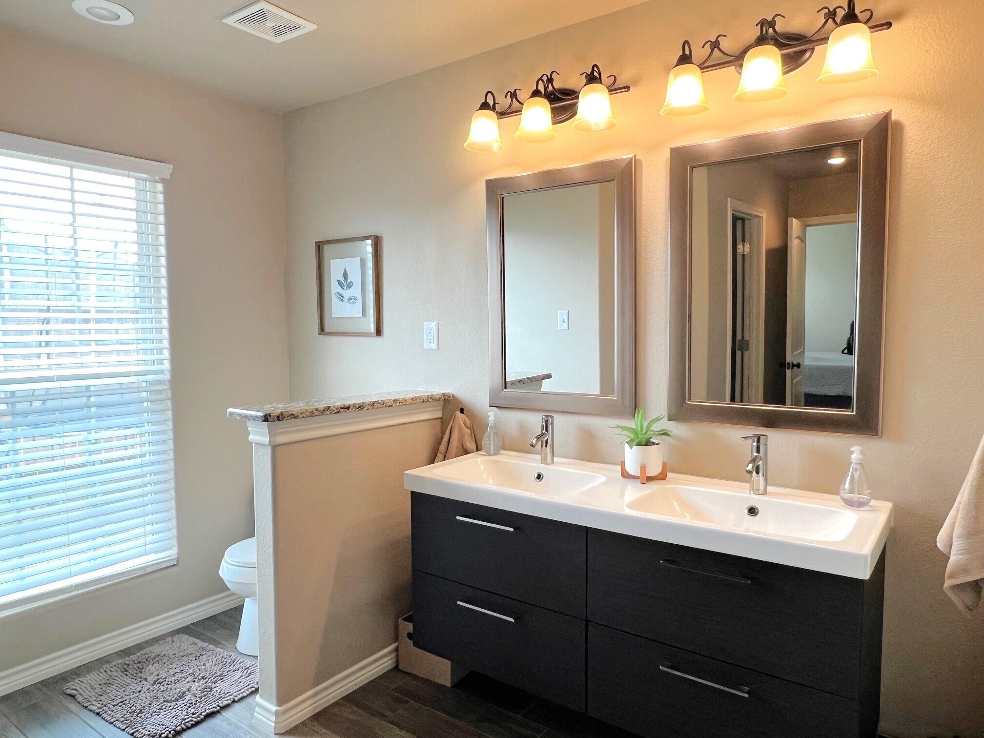 8803 10th Place Lubbock, TX 79416 - Photo 17 of 27 a bathroom with a double vanity sink and a mirror