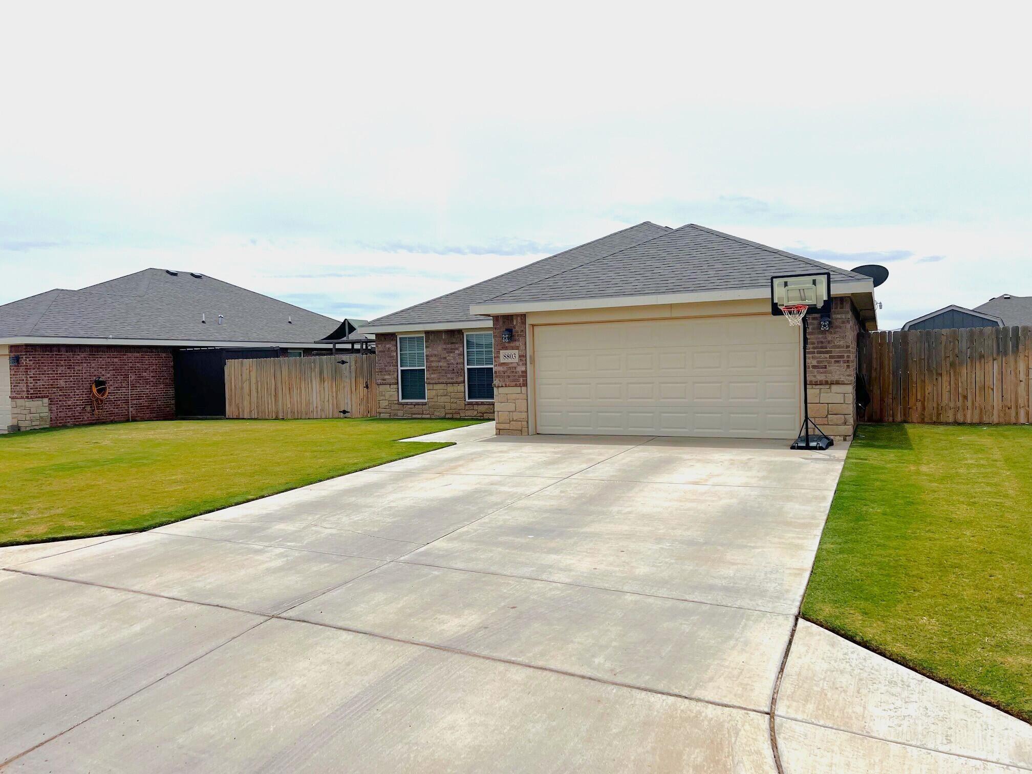 8803 10th Place Lubbock, TX 79416 - Photo 2 of 27 a front view of house with yard and garage