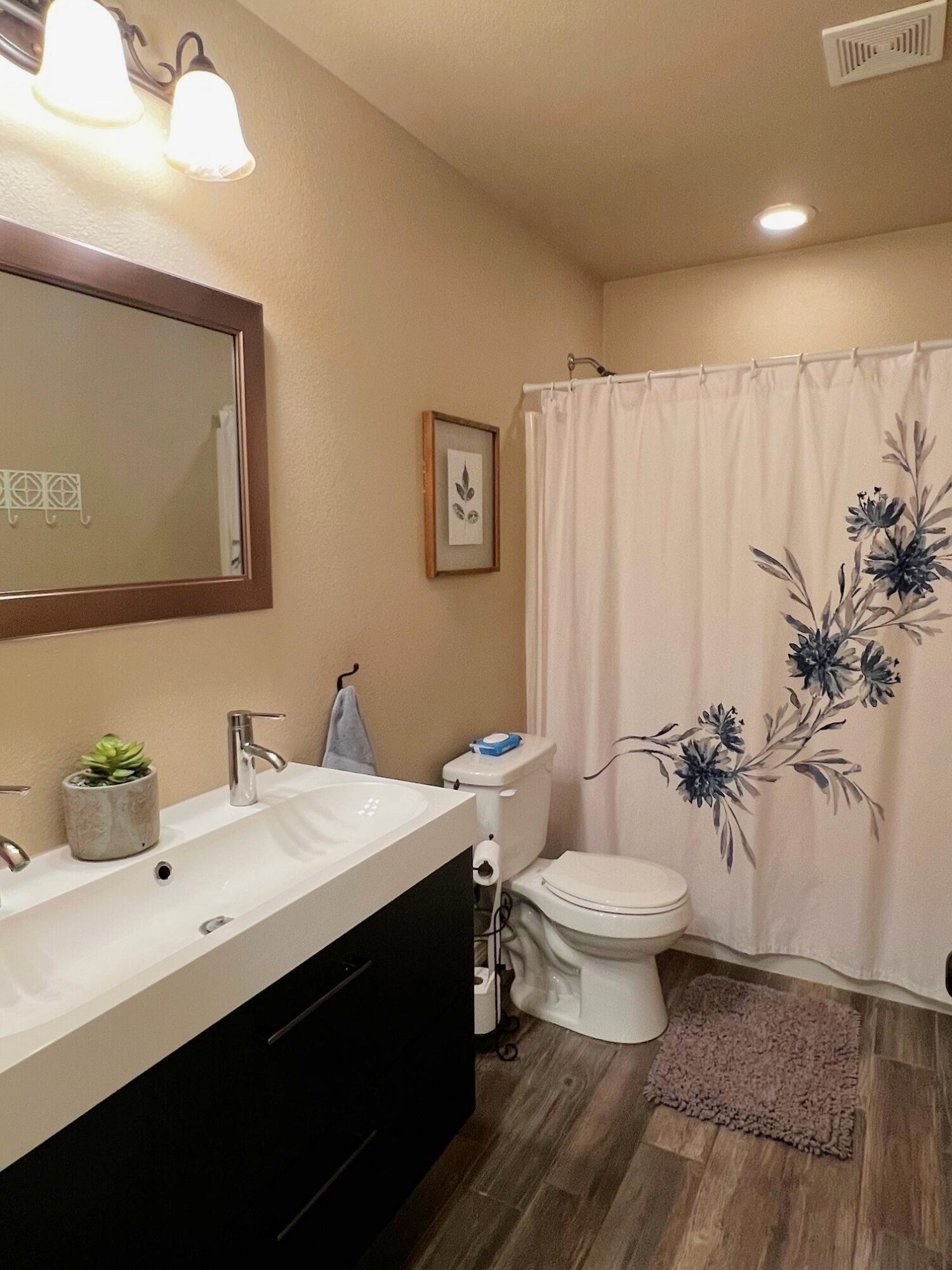 8803 10th Place Lubbock, TX 79416 - Photo 21 of 27 a bathroom with a toilet sink and mirror