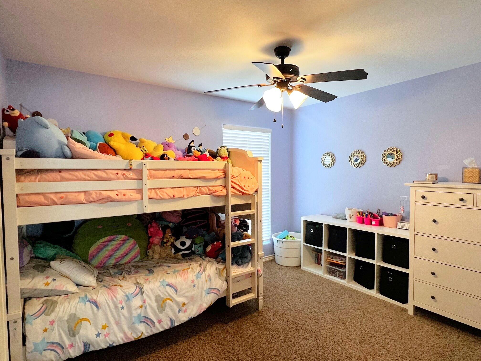 8803 10th Place Lubbock, TX 79416 - Photo 22 of 27 a bed room with a bed and a ceiling fan