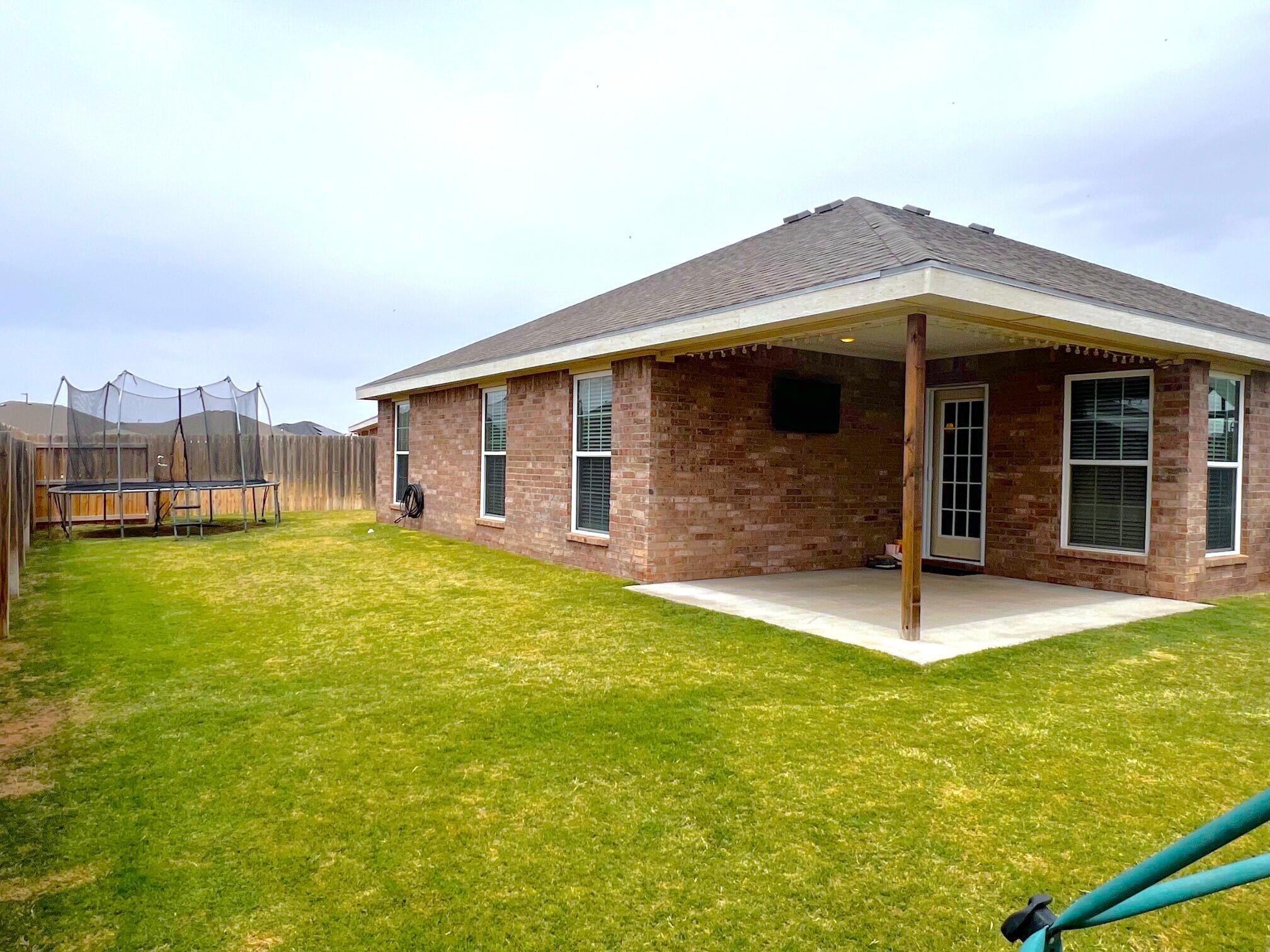 8803 10th Place Lubbock, TX 79416 - Photo 24 of 27 a front view of a house with a yard
