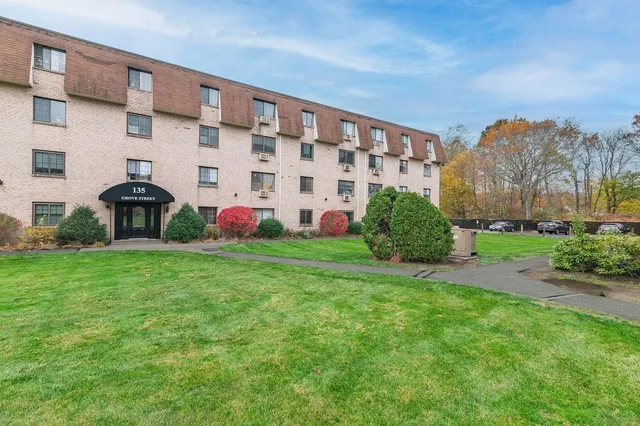 a view of building with garden and statue