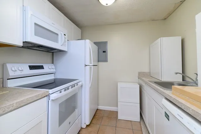 a kitchen with granite countertop a sink stove and refrigerator
