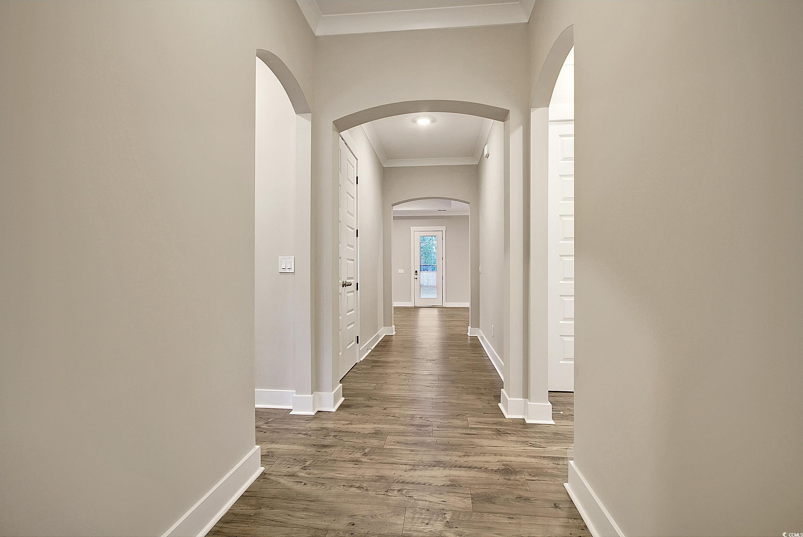 171 Pinebury Drive Georgetown, SC 29440 - Photo 19 of 30 Hall with ornamental molding, arched walkways, and dark wood finished floors