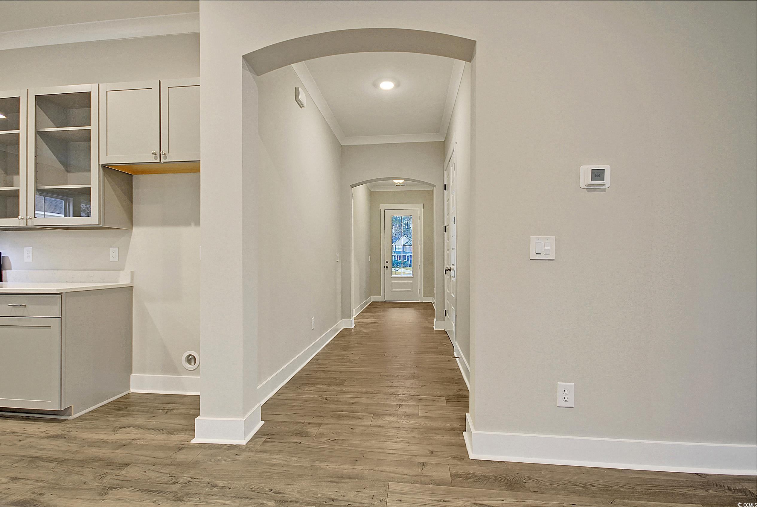 171 Pinebury Drive Georgetown, SC 29440 - Photo 20 of 30 Hallway with crown molding, light wood-style floors, and arched walkways