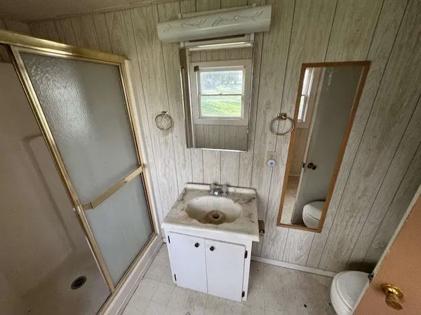 a bathroom with a sink and mirror with bathtub