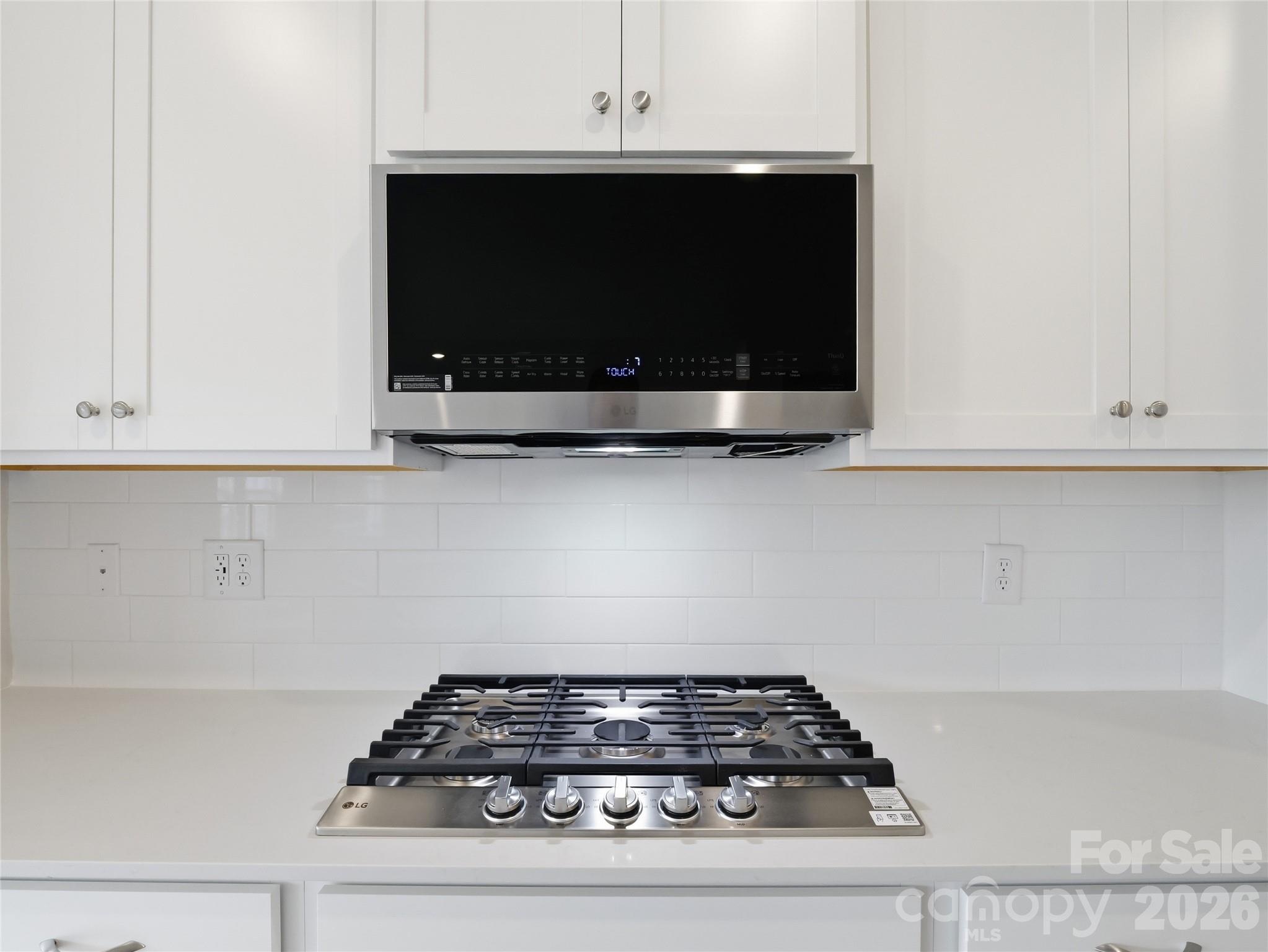5420 Redbud Road Lancaster, SC 29720 - Photo 12 of 32 a kitchen with white cabinets and black stove top oven with granite countertops