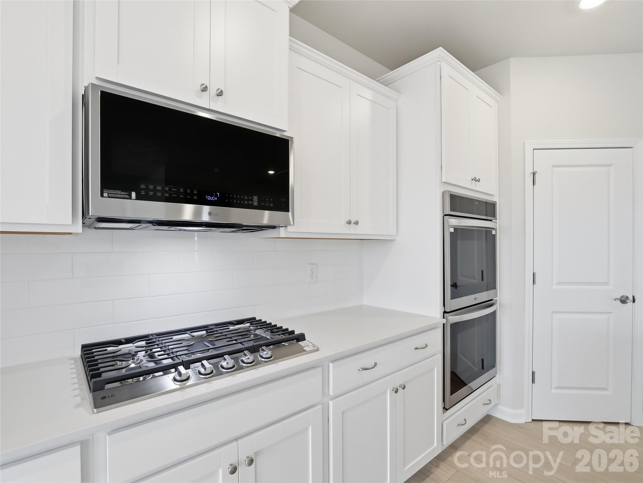 5420 Redbud Road Lancaster, SC 29720 - Photo 13 of 32 a kitchen with stainless steel appliances white cabinets and stove
