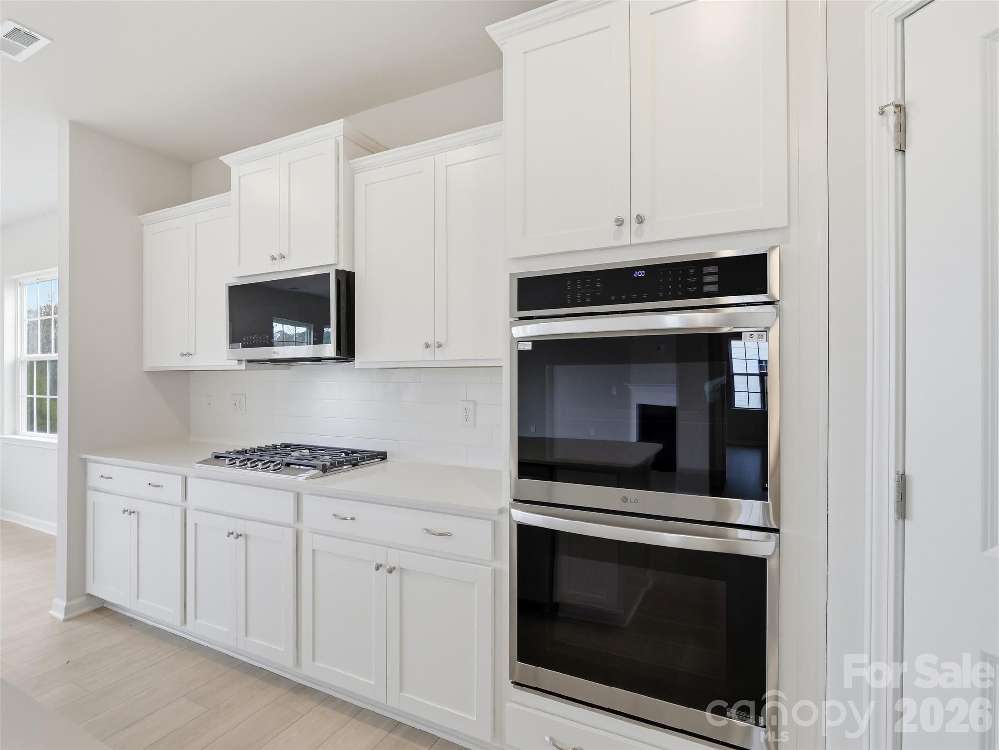 5420 Redbud Road Lancaster, SC 29720 - Photo 14 of 32 a kitchen with white cabinets and stainless steel appliances