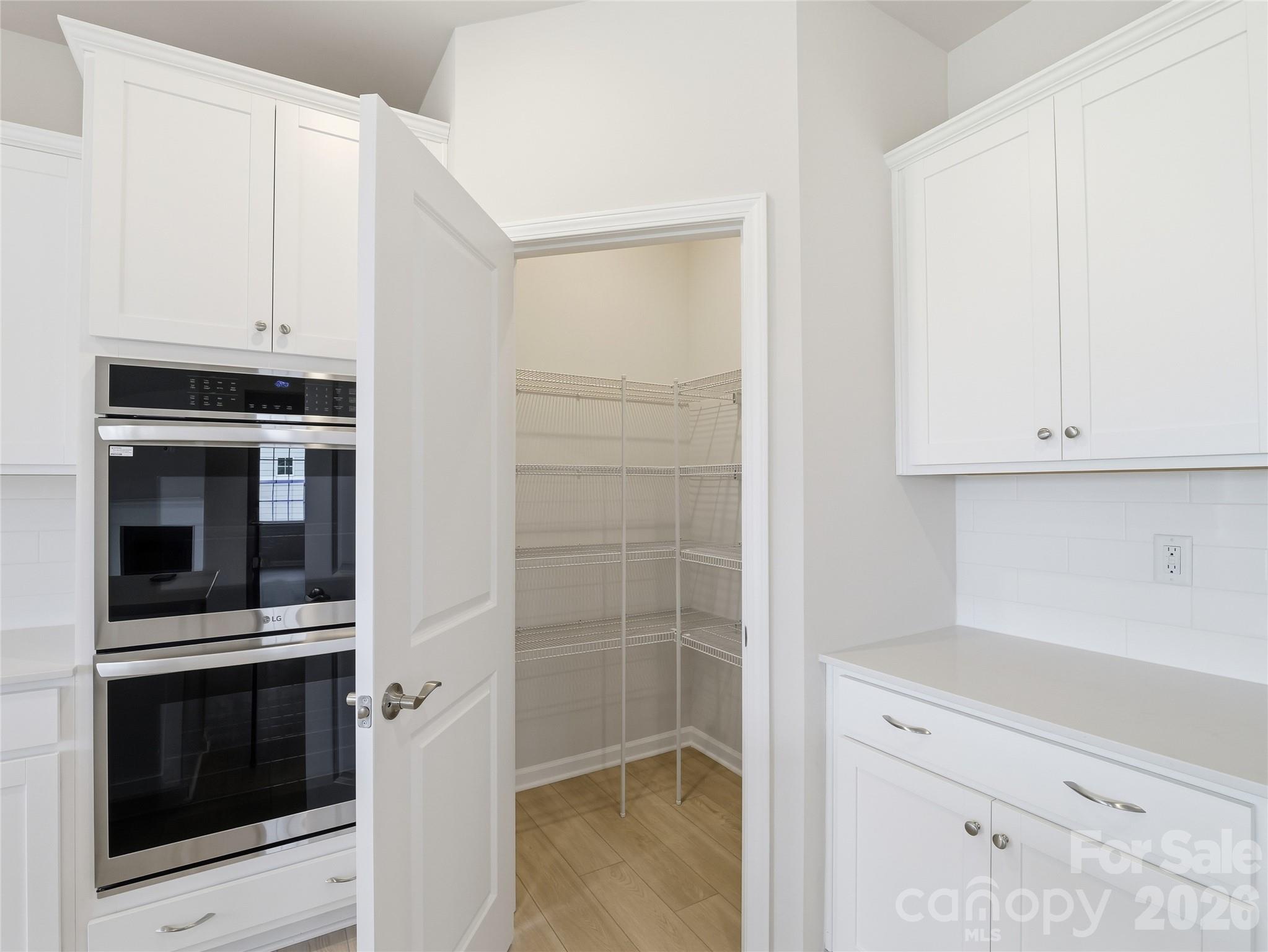 5420 Redbud Road Lancaster, SC 29720 - Photo 25 of 32 a kitchen with white cabinets and stainless steel appliances