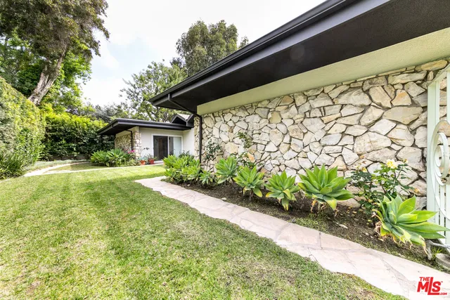 a view of house with backyard and garden