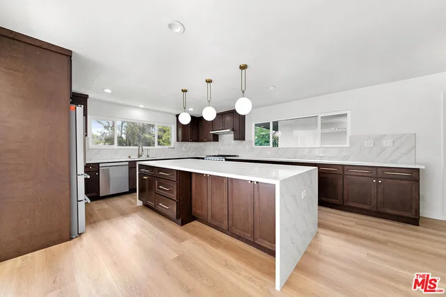 a large kitchen with a lot of counter space and stainless steel appliances
