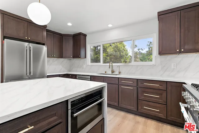 a kitchen with a sink appliances and cabinets