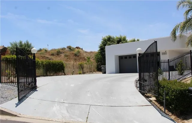 a front view of a house with a yard and potted plants
