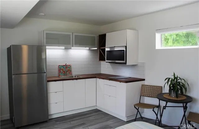 a kitchen with granite countertop a refrigerator and a stove top oven