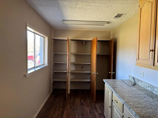 a bathroom with a granite countertop sink a vanity and a window