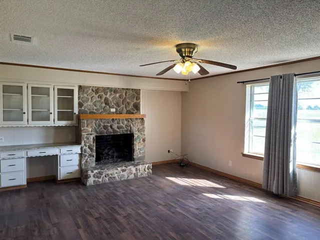 wooden floor fireplace and windows in an empty room