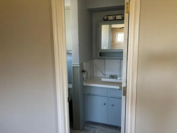 a view of bathroom with a sink and mirror