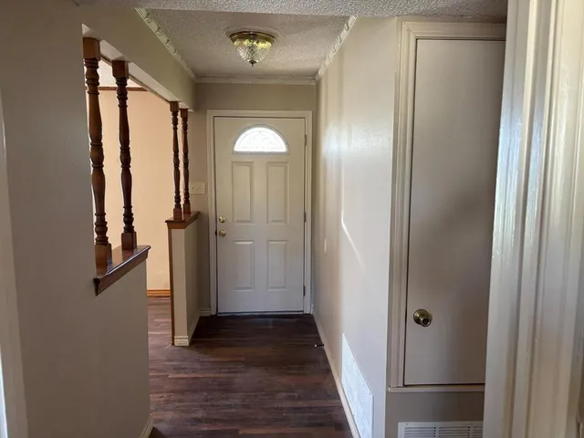a view of a hallway with wooden floor and staircase