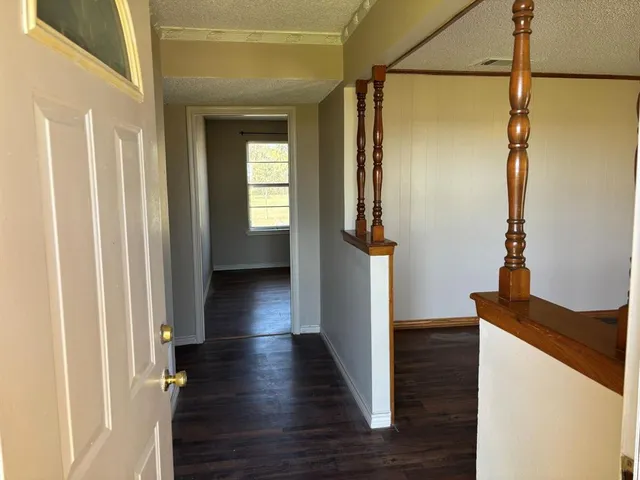 a view of a hallway with wooden floor and staircase