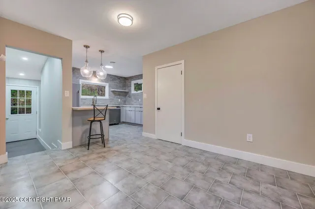 a kitchen with stainless steel appliances kitchen island granite countertop a sink a stove and refrigerator