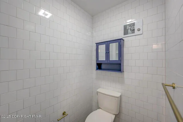a bathroom with a granite countertop toilet sink and mirror