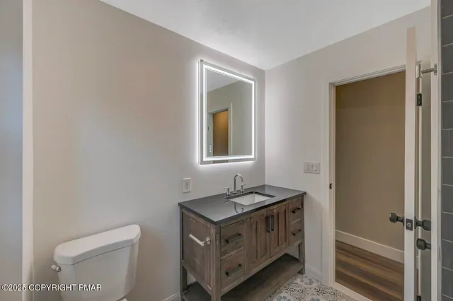 a backyard of a house with plants and large tree