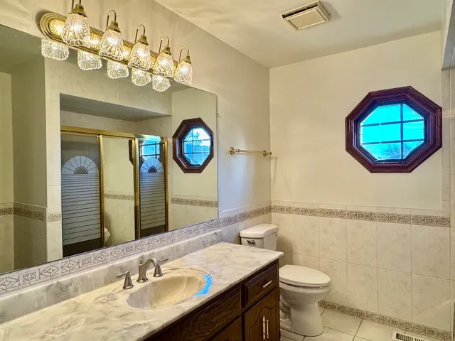 a bathroom with a toilet a sink and mirror