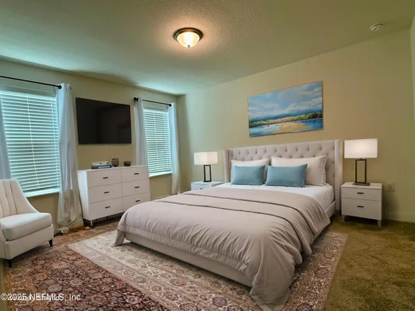 a spacious bedroom with a bed and a flat screen tv