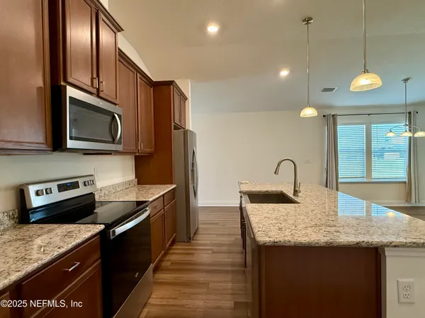 a kitchen with stainless steel appliances granite countertop a sink a stove and oven