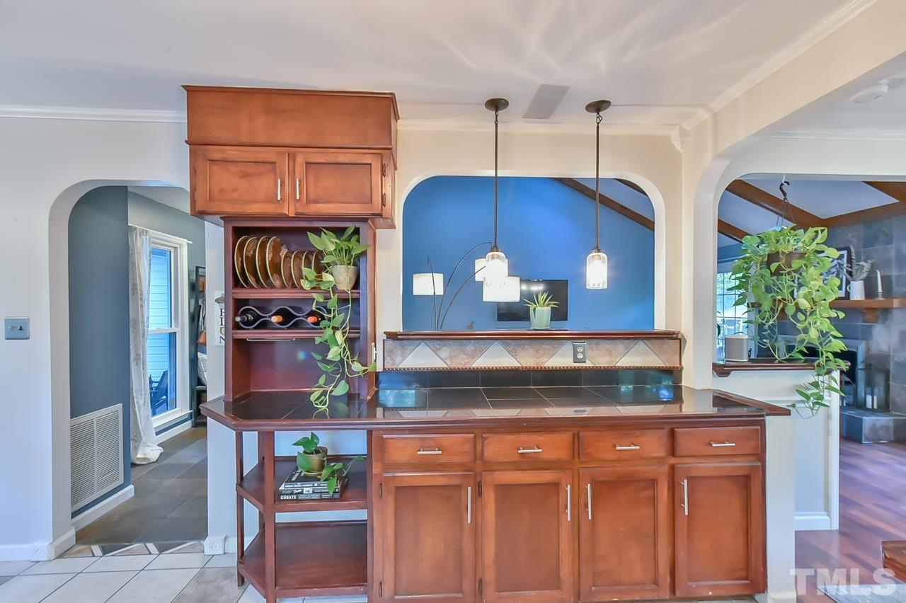 7204 Ray Road Raleigh, NC 27613 - Photo 25 of 40 a kitchen with stainless steel appliances granite countertop a stove and a wooden cabinets