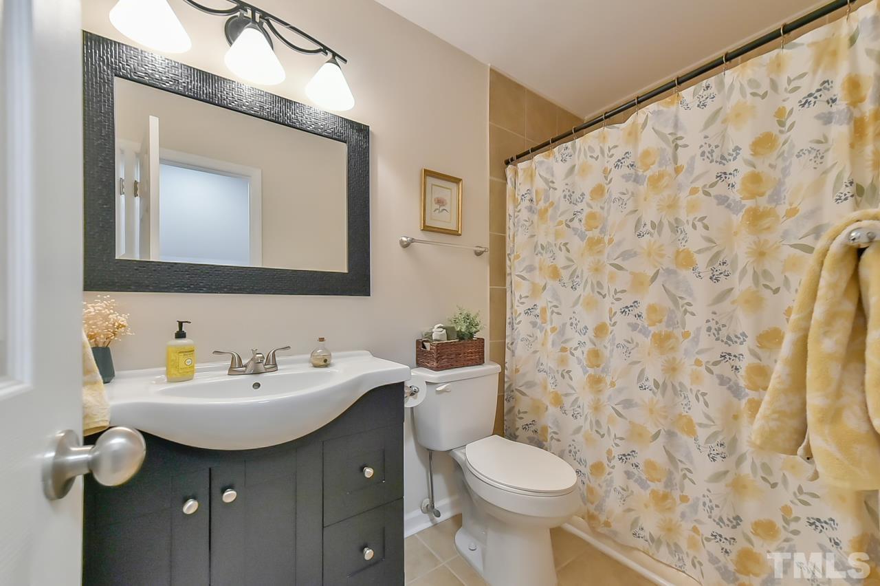 7204 Ray Road Raleigh, NC 27613 - Photo 28 of 40 a bathroom with a toilet sink and mirror
