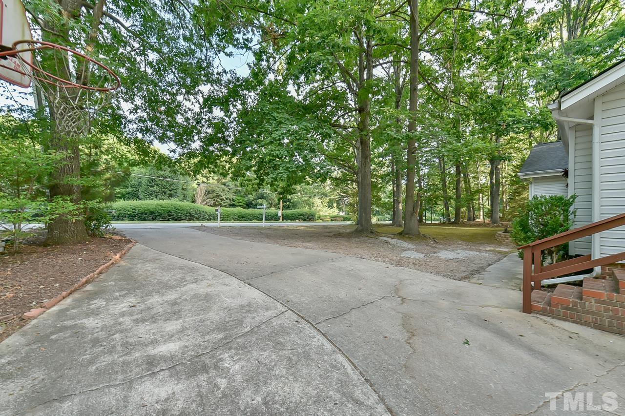 7204 Ray Road Raleigh, NC 27613 - Photo 3 of 40 a view of a yard with potted plants and large trees