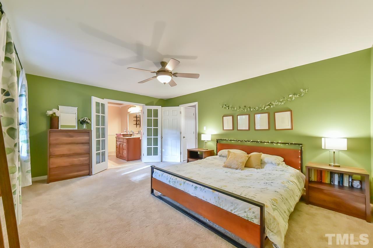 7204 Ray Road Raleigh, NC 27613 - Photo 36 of 40 a bedroom with a large bed and a chandelier