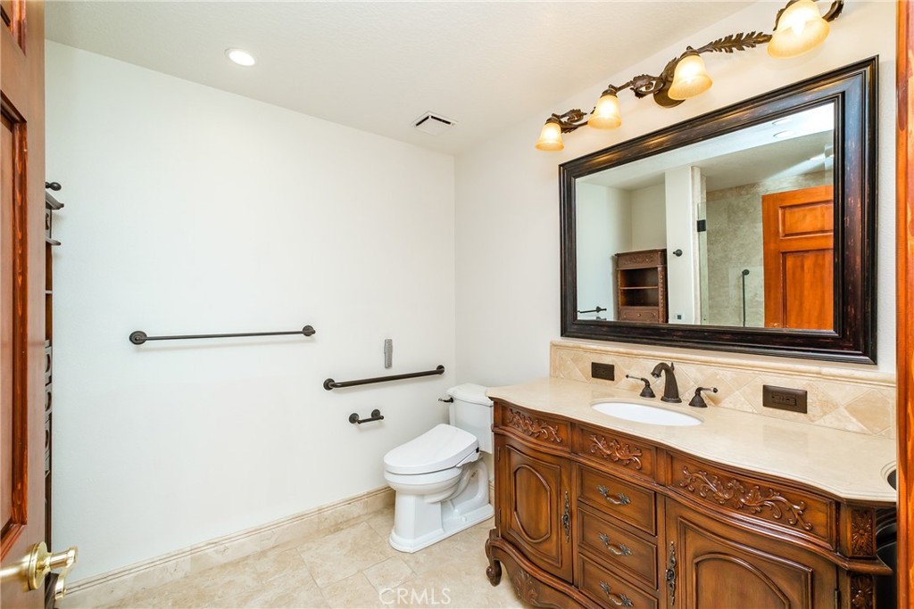 19670 Tonkawan Road Apple Valley, CA 92307 - Photo 21 of 29 a bathroom with a toilet sink double vanity and mirror