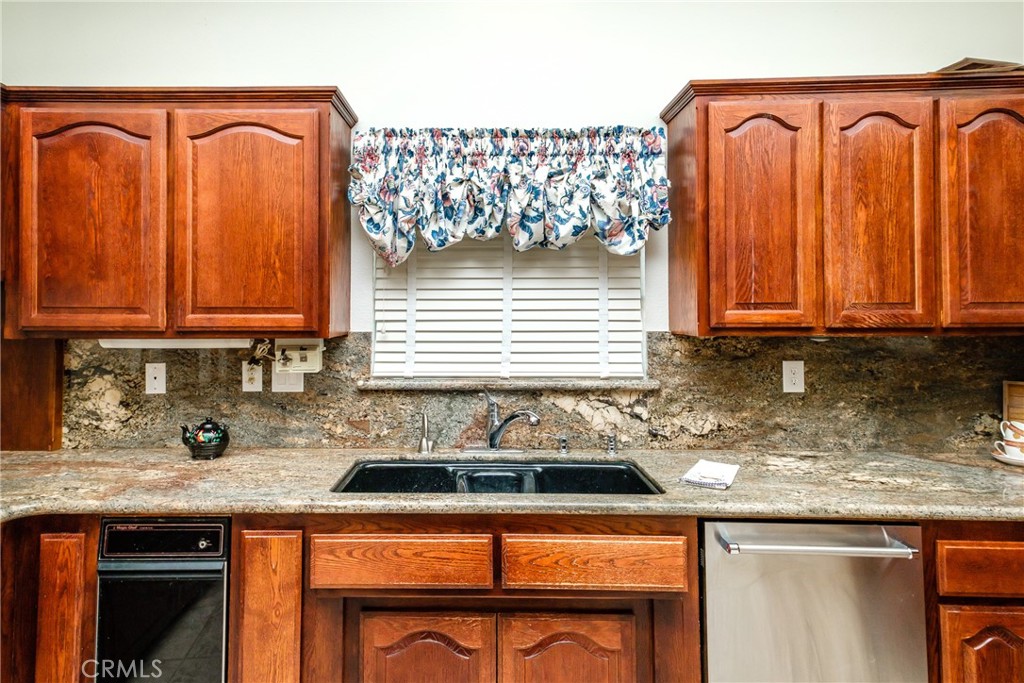 19670 Tonkawan Road Apple Valley, CA 92307 - Photo 9 of 29 a kitchen with granite countertop a sink a stove and cabinets