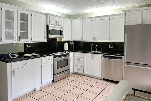 a kitchen with white cabinets and white appliances