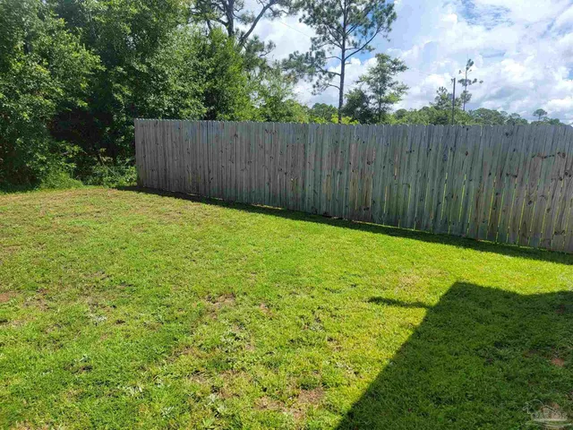 a view of a backyard with wooden fence