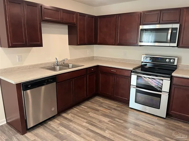 a kitchen with a sink and steel appliances